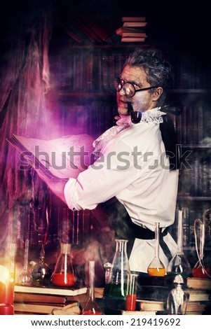 Crazy medieval scientist working in his laboratory with old manuscripts. Alchemist. Halloween.