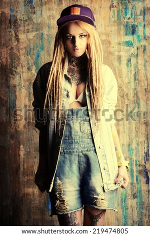 Modern teenage girl with blonde dreadlocks. Jeans style. Modern generation.