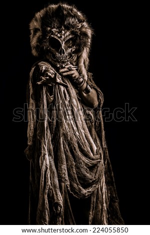 Frightening female wearing mask of skull. Fantasy. Halloween. Witchcraft, voodoo dances.