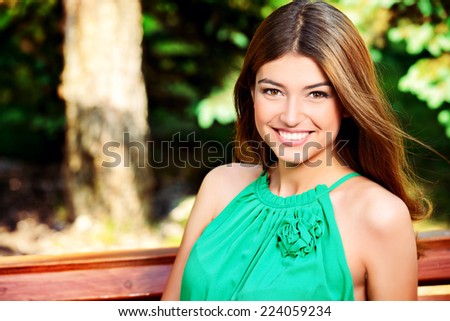 Romantic young woman with beautiful smile having a rest outdoor.
