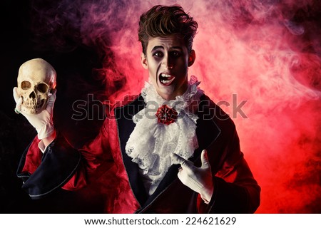Comic vampire holding a skull. Halloween. Dracula costume.