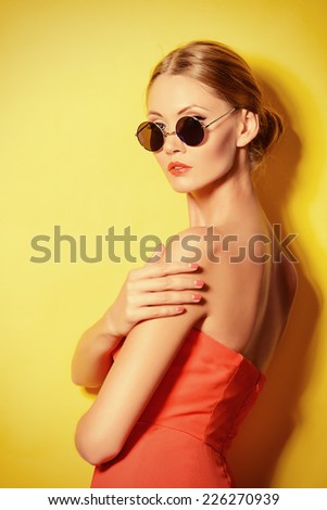 Beautiful elegant lady over bright yellow background. Beauty, fashion concept. Optics.