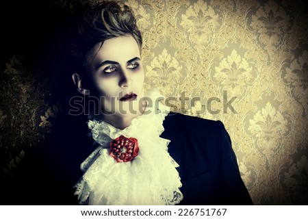 Portrait of a handsome male vampire over vintage background. Halloween. Dracula costume.