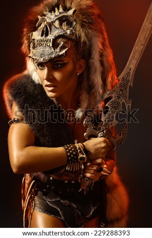 Beautiful bellicose Amazon with a sword in battle. Ancient times. Fantasy.