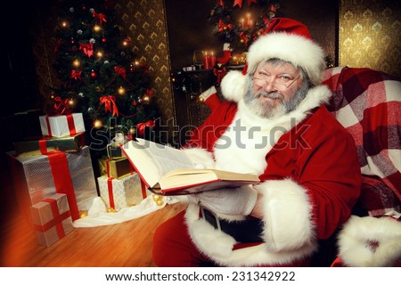 Santa Claus sat down to rest by the fireplace and to read a book. Home decoration.