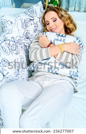 Happy elegant woman having a rest in her bedroom.