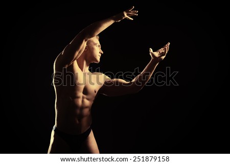 Handsome muscular athletic man posing over black background. Men\'s beauty. Bodybuilding. Sports.