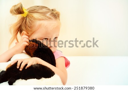 Sad little girl hugging her toy.