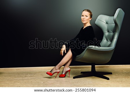 Portrait of a stunning fashionable model sitting in a chair in Art Nouveau style. Business, elegant businesswoman. Interior, furniture.