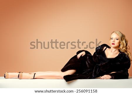 Beautiful blonde woman wearing mink fur coat. Fashion, beauty. Luxurious lifestyle. Studio shot.