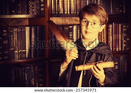 A boy stands in the library by the bookshelves with many old books and holds old manuscripts. Educational concept. Science. Vintage style.
