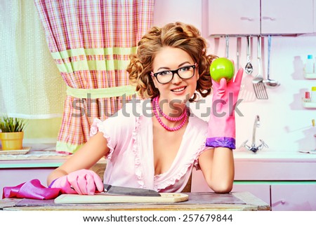 Sexy pin-up girl wearing pink bathrobe alluring on her pink kitchen at home. Fashion.