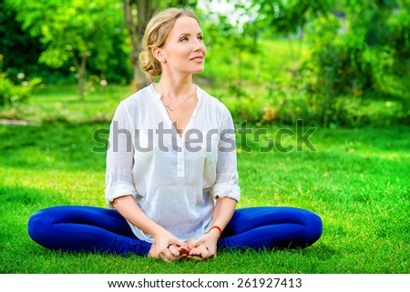 Beautiful young woman doing yoga in the summer park. Healthy lifestyle. Yoga. Lotus pose.
