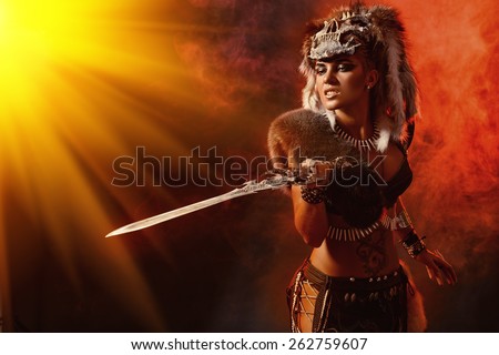 Beautiful bellicose Amazon with a sword in battle. Ancient times. Fantasy.
