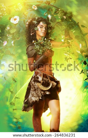 Fabulous female Faun in a fairy garden. Fantasy world. Body painting project.