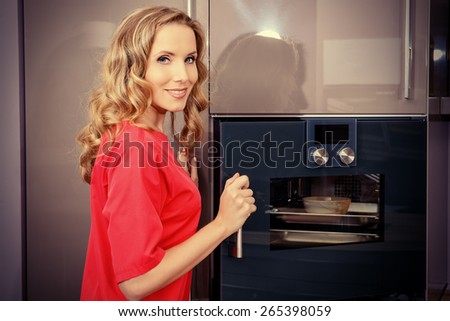 Elegant young woman cooking in the kitchen at home. Healthy eating. Home interior. Furniture.