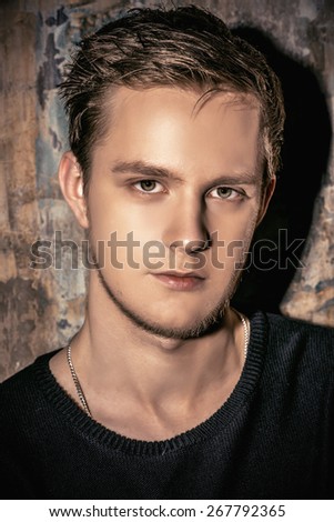 Close-up portrait of a handsome young man over grunge background. Men\'s beauty, fashion.