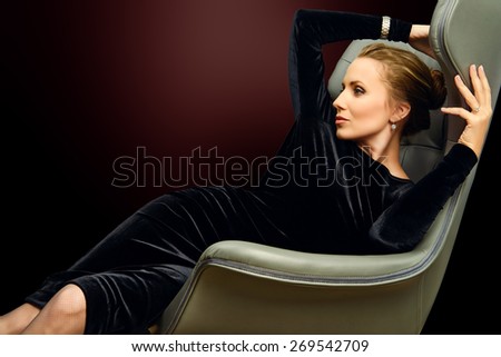 Portrait of a stunning fashionable model sitting in a chair in Art Nouveau style. Business, elegant businesswoman. Interior, furniture.
