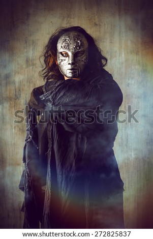 Scary man in iron mask and black robe. Fantasy. Halloween.