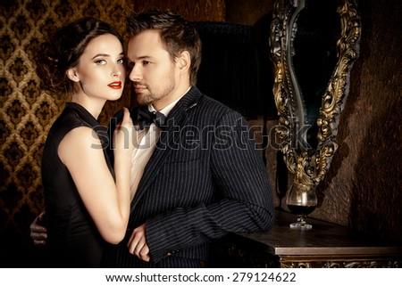 Beautiful man and woman in elegant evening clothes in classic vintage apartments. Glamour, fashion. Love concept.