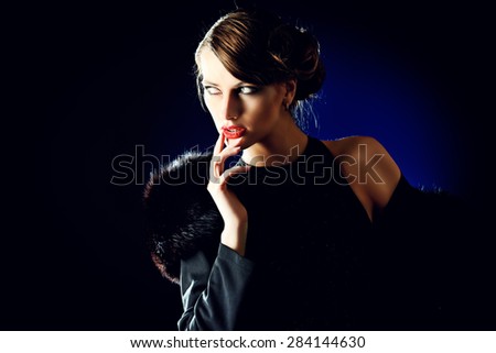 Glamorous young woman with evening make-up over dark background. Luxury. Beauty, fashion. Make-up.