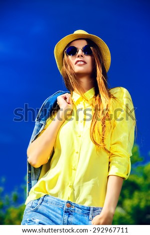 Beautiful happy girl wearing casual jeans clothes enjoys sunny summer day. Beauty, fashion shot.