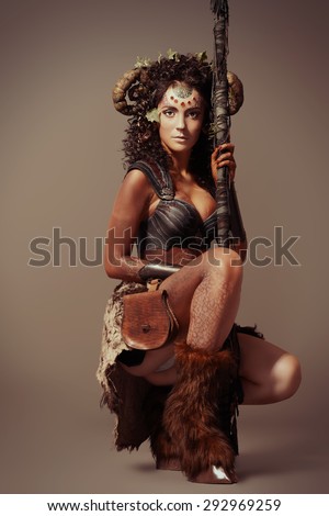 Full length portrait of a fairy female Faun with magic stick. Myth and fantasy. Body painting project. Studio shot.