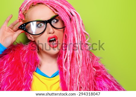 Modern pin-up girl in bright clothes and pink dreadlocks. Disco, party. Bright fashion.