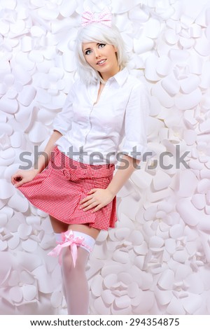 Lovely girl wearing white wig and white blouse with plaid skirt posing over  background of white paper flowers. Anime style.