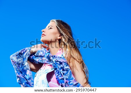 Beautiful dreamy girl looking into the distance over blue sky. Summer style. Holidays. Beauty, fashion.