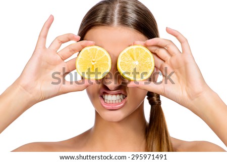 Funny laughing woman holding two juicy lemons before her eyes. Healthy eating concept. Diet. Isolated over white.