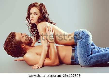 Beautiful young people in love. Studio shot. Jeans style.