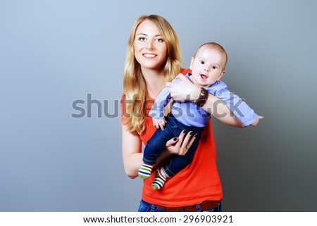 Happy beautiful mother holds her adorable baby. Family concept. Studio shot.