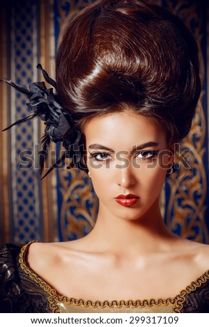 Close-up portrait of a beautiful baroque woman in elegant historical dress and with barocco updo hairstyle over vintage background. Renaissance. Barocco. Fashion.
