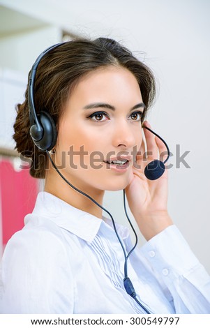 Beautiful smiling customer service woman talking on headset. Business, office life.