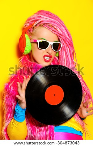 Glamorous modern DJ girl posing with vinyl record. Disco, party. Bright fashion.