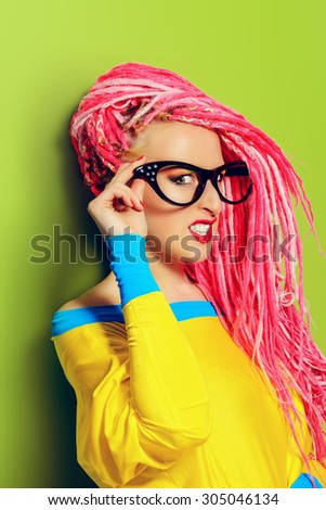 Modern pin-up girl in bright clothes and pink dreadlocks. Disco, party. Bright fashion.