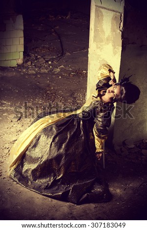 Art Fashion. Beautiful young woman in elegant historical dress and with barocco updo hairstyle posing in the ruins of the castle. Renaissance. Barocco.