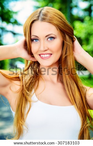 Portrait of a beautiful young woman smiling to a sunny summer day. She is absolutely happy. Beauty, fashion.