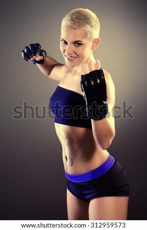 Portrait of a professional athlete woman bodybuilder with a perfect athletic physique. Fitness sports. Healthcare, bodycare. Martial arts, fighter.