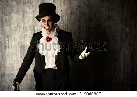 Handsome male vampire in a tail-coat and top-hat. Halloween. Dracula costume.