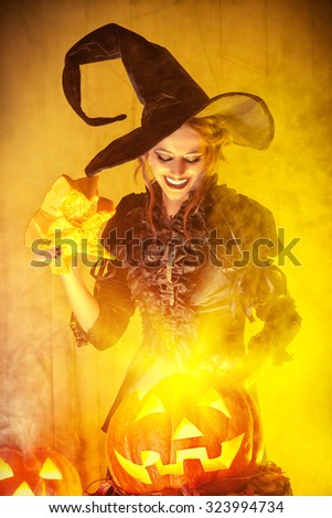 Enchanting witch and pumpkin with shining eyes. Halloween concept.