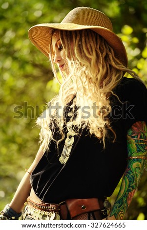 Boho style fashion. Beautiful young woman wearing boho style clothes posing in the rays of the evening sun, sunset.