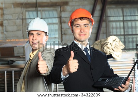 Industrial theme: two businessman showing good results at a manufacturing area.