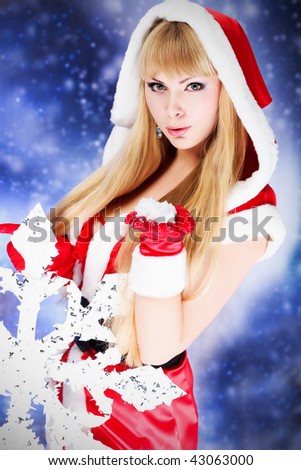 Portrait of a beautiful young woman wearing christmas clothes over sky of stars and snow.