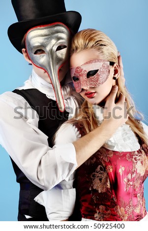 Portrait of the elegant young couple in masquerade costumes. Shot in a studio.