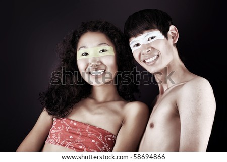 Shot of artistic young people with painted eyes posing together.
