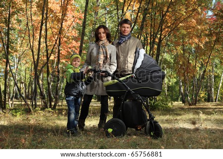 Happy family with two children walking at the autumn park.