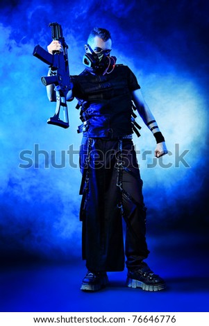 Shot of a conceptual man in a respirator holding a gun.