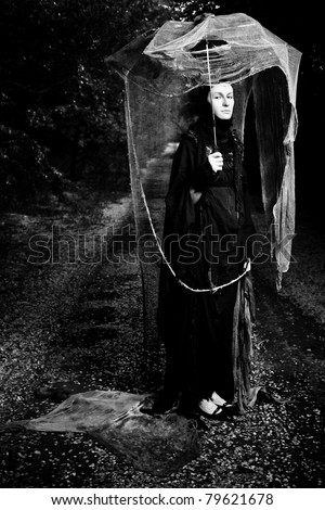 Shot of a sad woman in mask wearing old-fashioned dress.